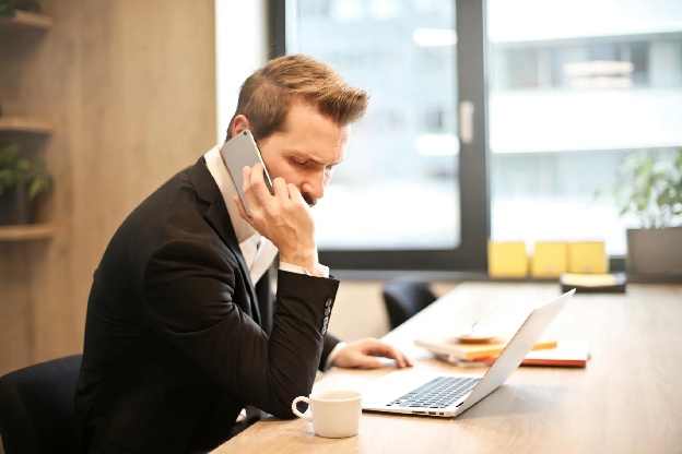 Man Having a Phone Call In-front of a Laptop. Photo by Andrea Piacquadio on pexels.com