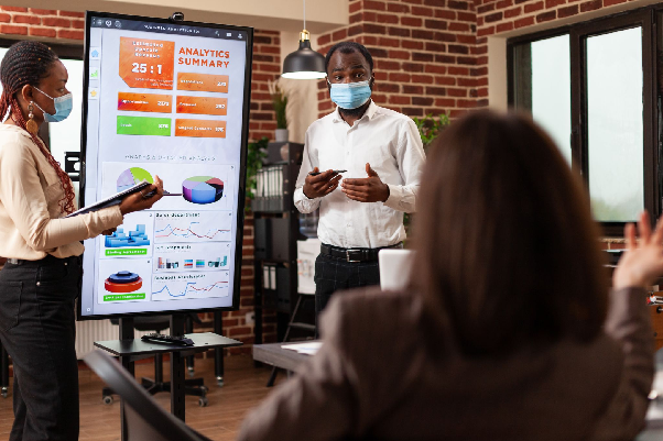 Man wearing a face mask making a powerpoint presentation