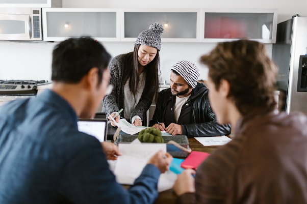 People around a table looking at documents. Photo by RDNE Stock project oon pexels.