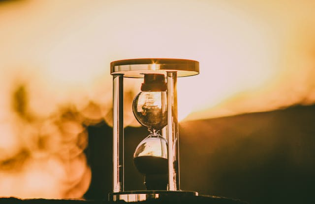 Close-up of an hourglass capturing the essence of time against a sunset backdrop. Photo by Samer Daboul on pexels.com