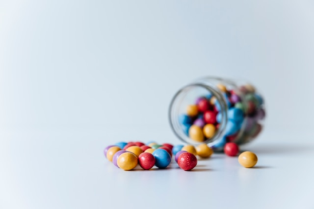 A glass jar filled with colorful candies on top of a table. Photo by Markus Spiske on unsplash.com
