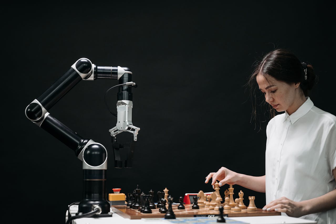 Woman in White Shirt Playing Chess against a Robot. Photo by Pavel Danilyuk on pexels.com