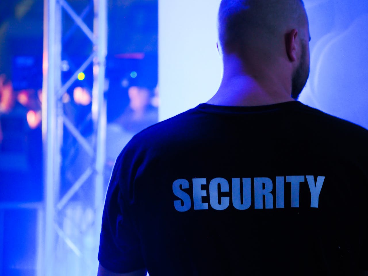 Back View of a Bouncer wearing a shirt with "Security". Photo by energepic.com from pexels.com