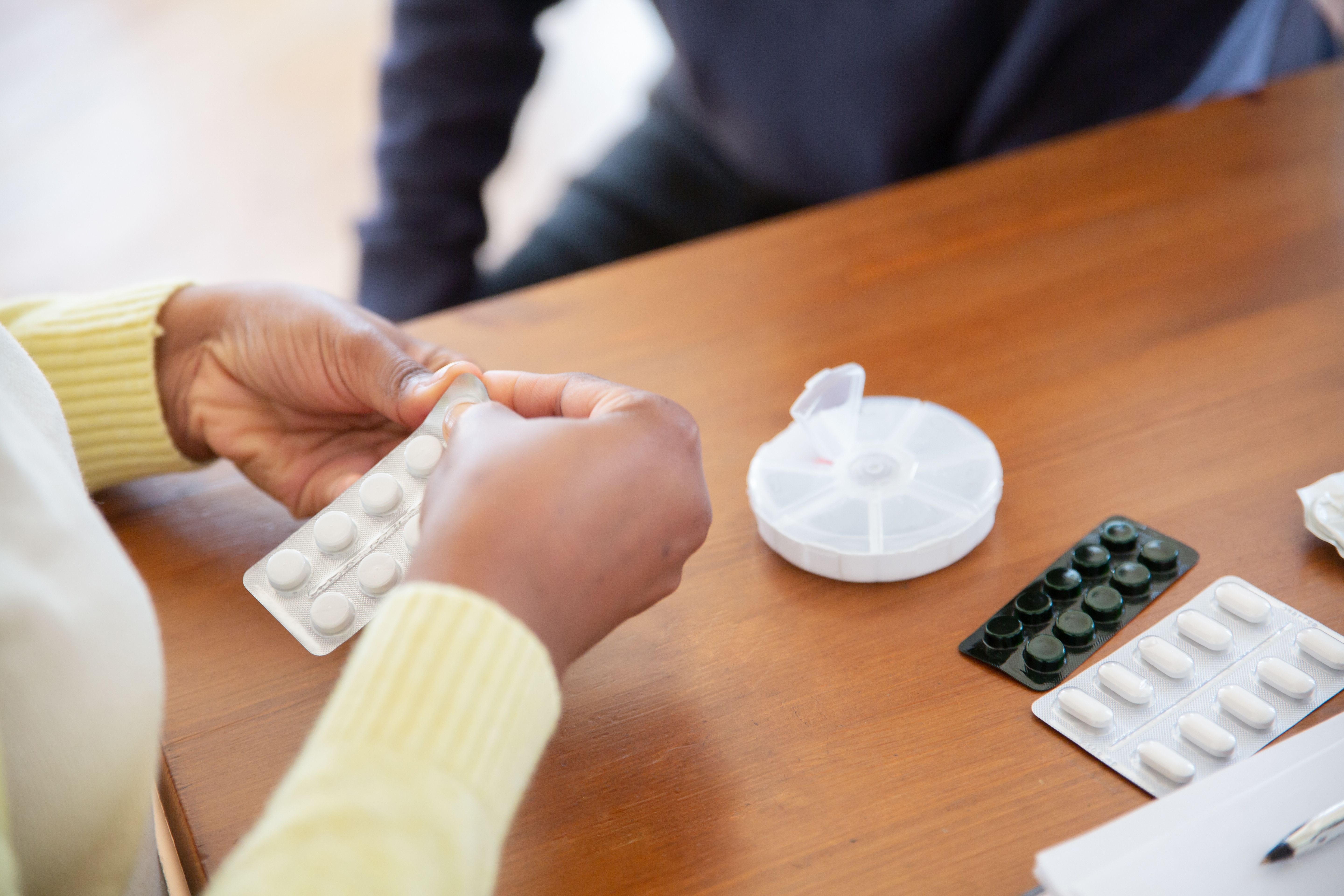 Close-up of a nurse organizing pills and medications on a table in a care setting. Photo by Kampus Production on pexels.