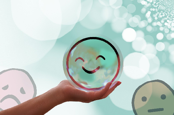 Hand holding a bubble with a smiley face