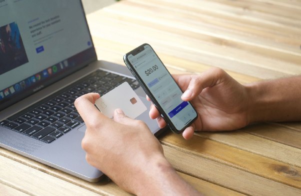 Person holding a phone and credit card in both hands. Photo by Michael lima on Unsplash