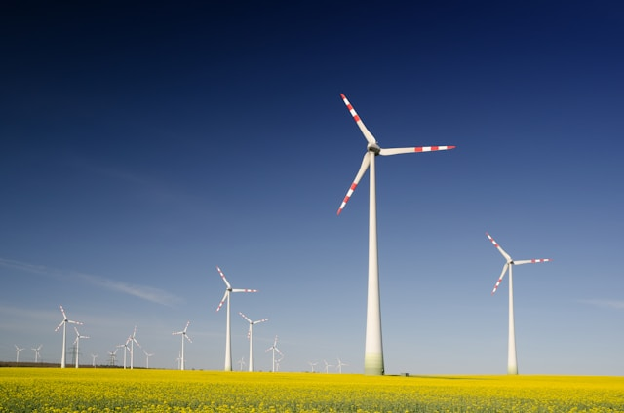 Windmills on grass field at daytime. Photo by Zbynek Burival.