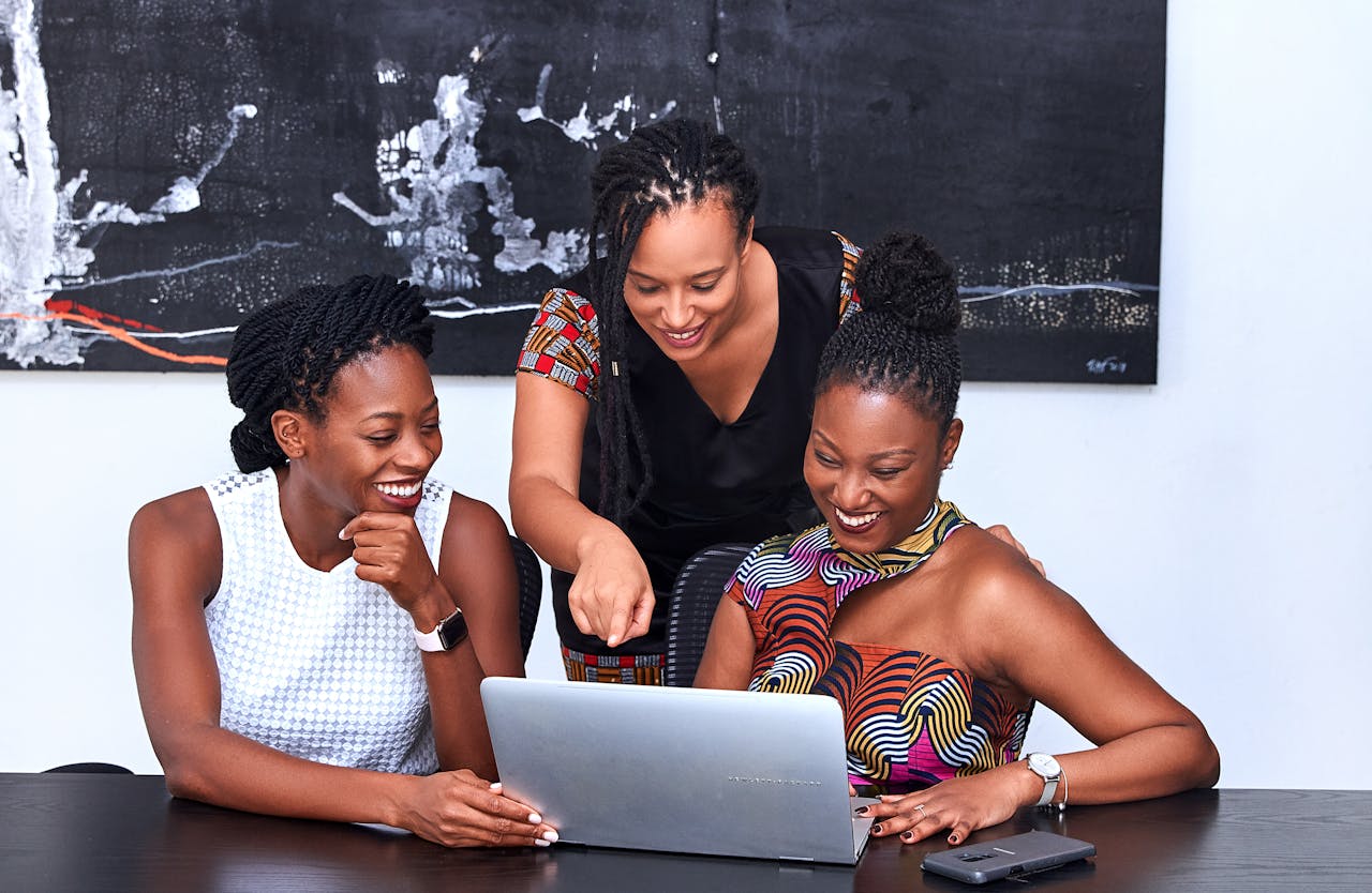 Three women looking at a laptop. Photo By: PICHA Stock on pexels.com