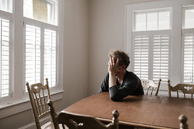 Photo of Man Leaning on Wooden Table. Photo by Andrew Neel on pexels.com