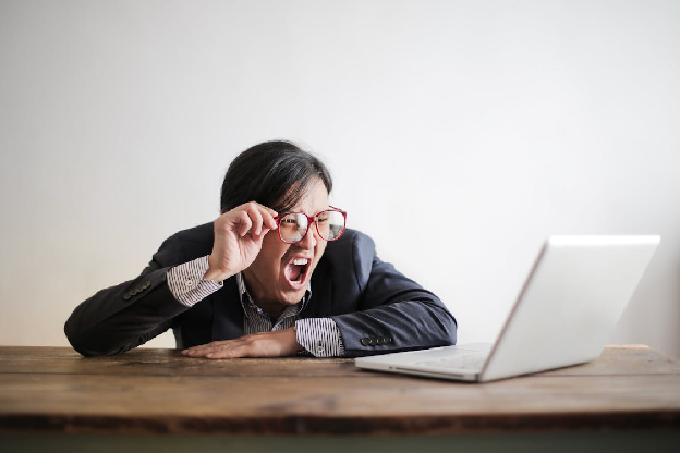 Yelling formal man watching news on laptop. Photo by Andrea Piacquadio on pexels.com